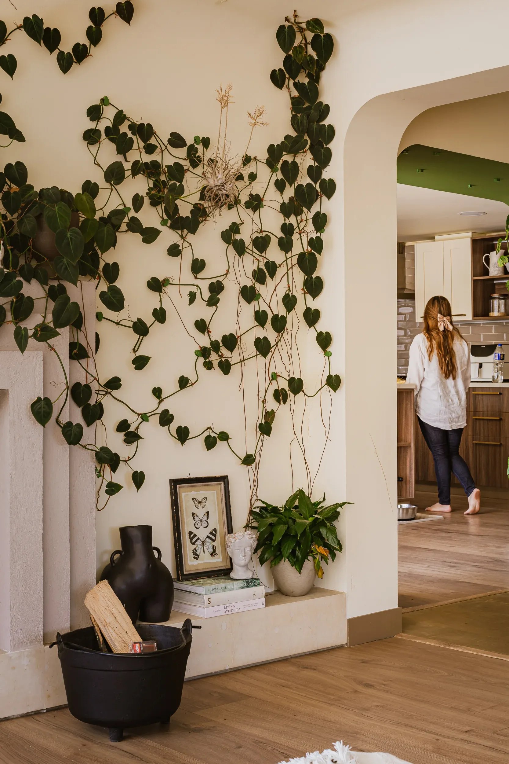 Planta colgante en la pared con Carolina caminando de espaldas