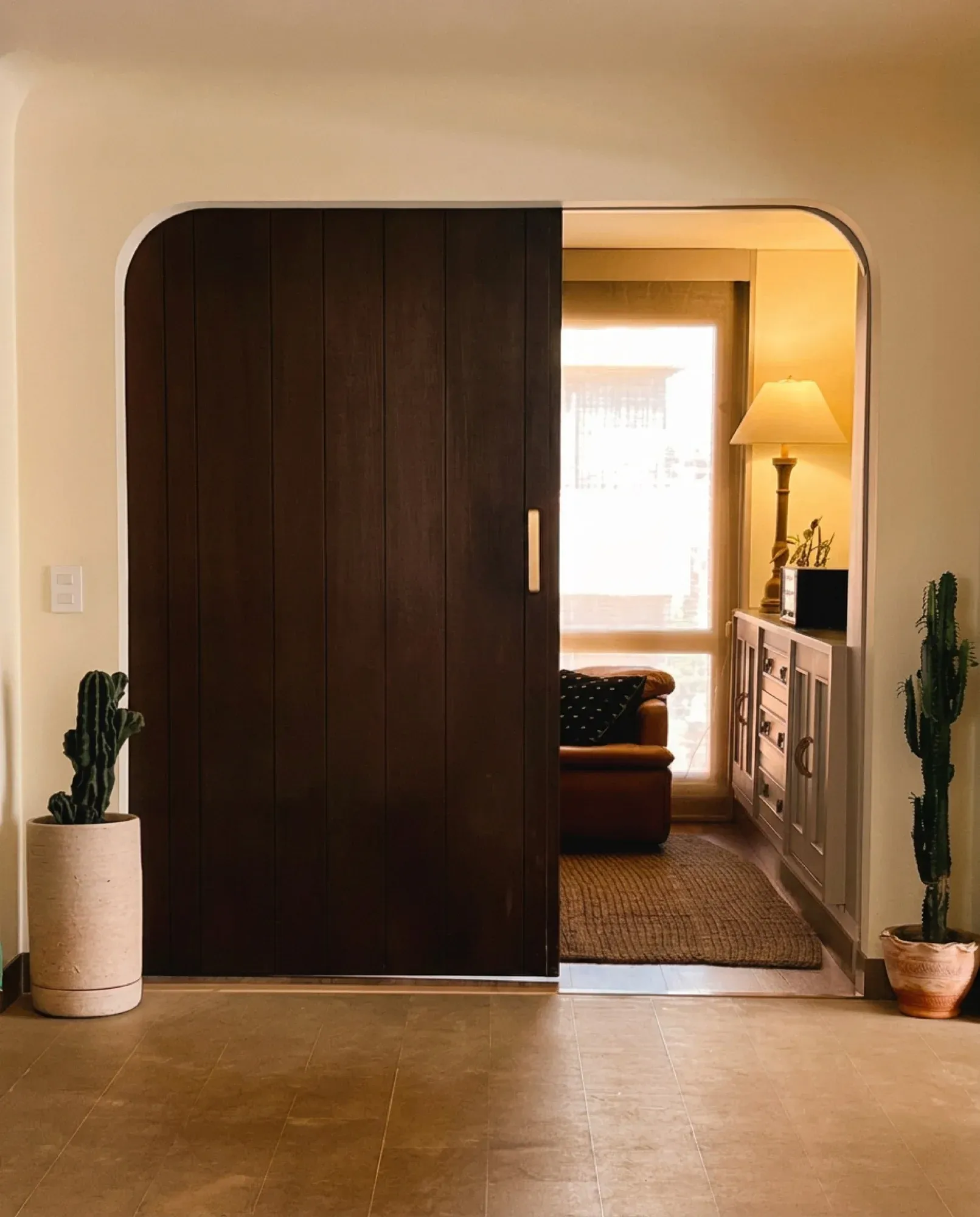 Puerta corrediza de madera que se abre hacia una sala cálida y acogedora