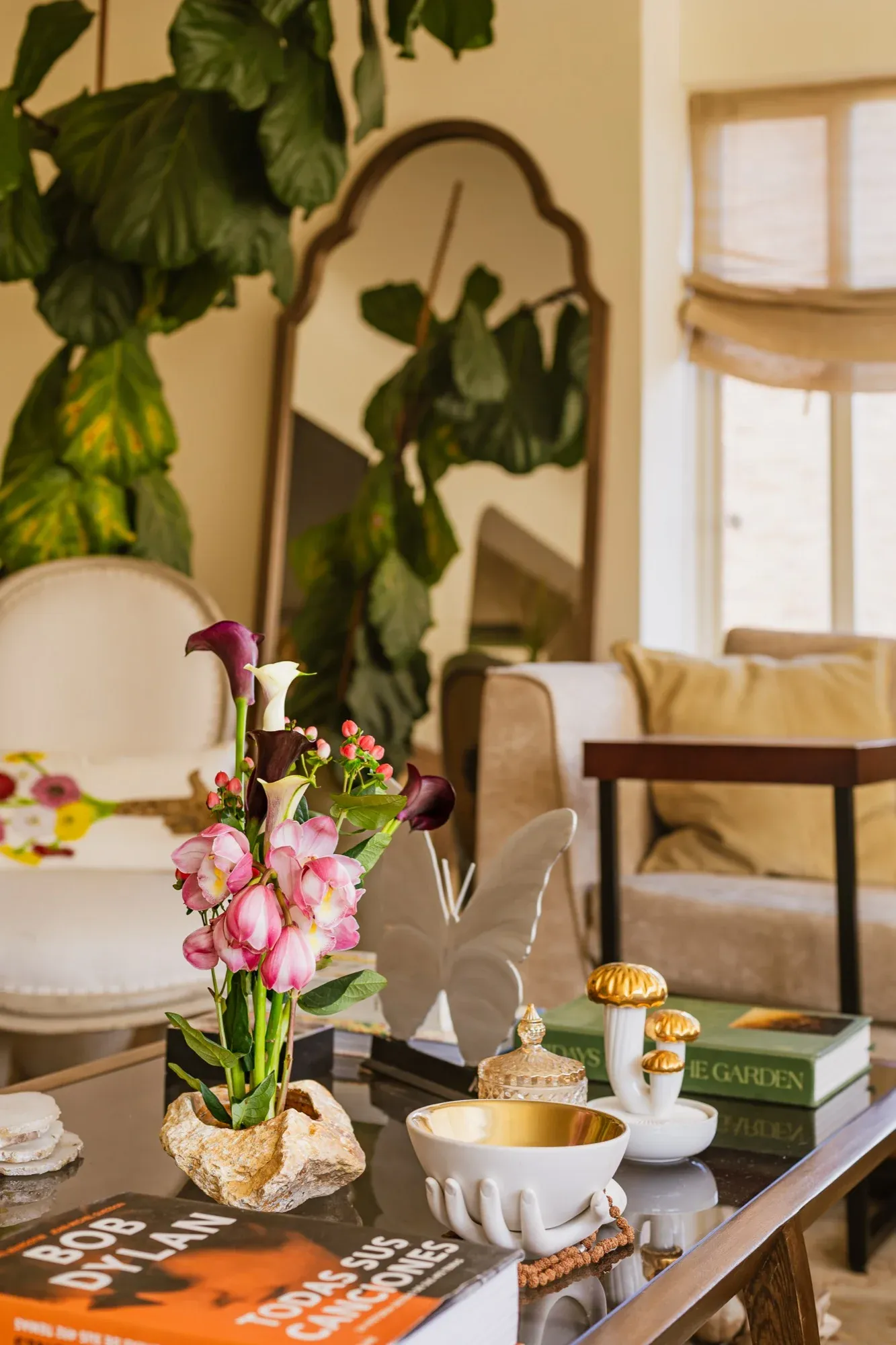 Rincón de una sala con flores, un espejo antiguo y objetos con historia