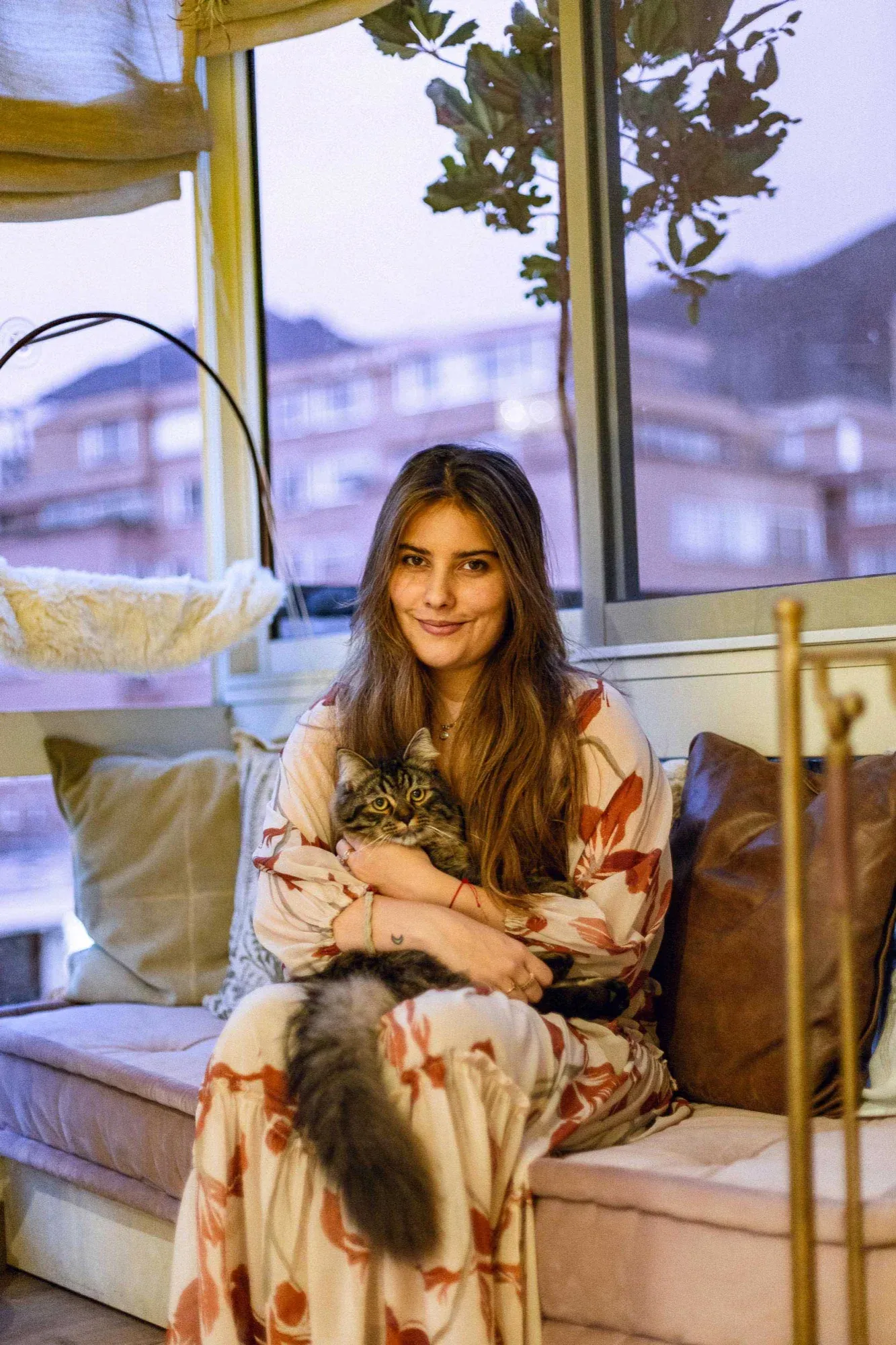 Carolina Rodríguez sonriendo junto a su gato en su hogar